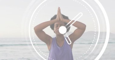 Orta yaşlı bir kadın, yoga meditasyonuna el kaldırıyor şafak plajında nefesini sayan dairesel zamanlayıcıyı gösteriyor. Dinginlik, farkındalık, sağlık, sükunet, yansıma, doğal, ruhani