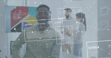 Oturan veri analisti tablet tıklamasına tepki verirken masaların üzerindeki paneller de işbirliğini sağlıyor. Teknoloji, takım çalışması, yenilik, veri görselleştirme, çalışma alanı, dijital arayüz, işbirliği