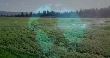 Drone görünümü dönüş kolu döndürmeye başlıyor, ekinleri püskürtüyor, holografik kürede yükselen veri düğümleri görülüyor. Tarım, teknoloji, dijital, yenilik, sürdürülebilirlik, hassasiyet, çevre