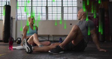 Spor salonunda oturan spor partnerleri yeşil ikili akışı görüp motivasyon için beşlik çakıyorlar. Egzersiz, yoldaşlık, dijital, yenilik, enerji, başarı, işbirliği