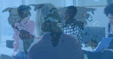 İş arkadaşları dinlenme odasında toplanıp basılı grafikleri inceleyerek dünya haritası oluşturuyorlar. İşbirliği, takım çalışması, veri analizi, dijital arayüz, yenilik, modern çalışma alanı