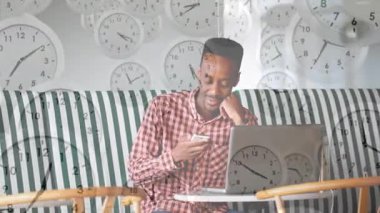 Akıllı telefonu dinleyen ve aktif hale getirilmiş saati çalıştıran bir adam bilgisayardan iş görüşmesine gönderme yapıyor. Teknoloji, iletişim, uzaktan kumanda, üretkenlik, dijital, gelişigüzel, modern