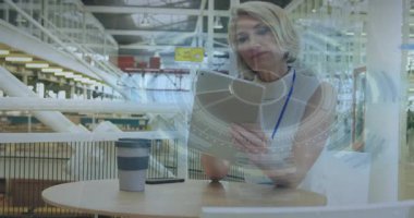 Olgun kadın tablete uzanıyor ve teknoloji incelemesi için yarı saydam UI grafiğini çalıştırıyor. Teknoloji, yenilik, üretkenlik, modern, profesyonel, dijital, çalışma alanı