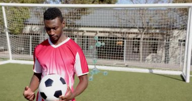 Erkek futbolcu topu incelerken moleküler modeller spor teknikleri gösterisinde gövdenin etrafında beliriyor. Sporcu, rekabet, yenilik, teknoloji, eğitim, enerji, performans