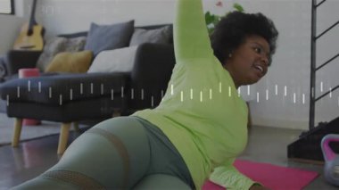 Bir kadın ön koluna doğru iniyor. Çekirdek zindelik kuvveti için yan tahtayı çalıştırıyor. Dalgalanma kuvveti senkronize nefes. Zindelik, güç, sağlık, farkındalık, ev, denge, kararlılık