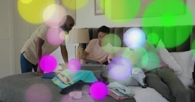 Olgun bir adam tableti tıkırdatıyor ve iki yolcunun bavullarını toplamasına rehberlik ediyor. İşbirliği, organizasyon, seyahat, paketleme, takım çalışması, hazırlık, yaşam tarzı