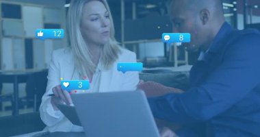 Kadın pisti tıkırdatıyor ve erkek laptop baloncuklarını izliyor. Online nişan büyümesini izliyorlar. İşbirliği, analitik, takım çalışması, modernlik, profesyonellik, dijital, yenilik