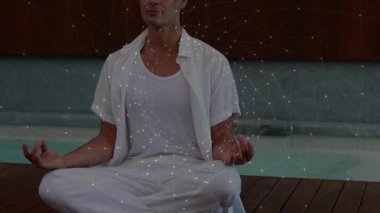 Güvertede bacak bacak üstüne atarak oturan bir adam, sağlık için parlayan bir ağ geliştiriyor. Farkındalık, sükunet, dijital, bağlantı, dinginlik, refah, meditasyon