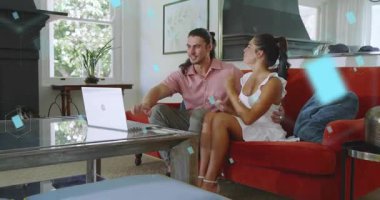 Kırmızı koltukta dizüstü bilgisayarı karıştıran çift mavi şekilleri başlatıyor ve online arama sırasında el sallıyorlar. Romantik, bağlantı, dijital, teknoloji, rahatlama, ev, çağdaş