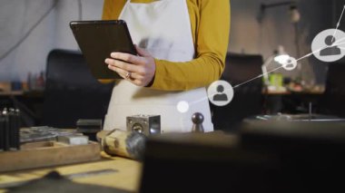 Teknoloji atölyesinde kadın zanaatkar tıklama tableti ve saydam ağ örtüsü haritalama verileri. Sanatçı, yenilik, teknoloji, işbirliği, el sanatları, çağdaş, bağlantı
