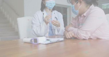 Doktor klinik masasına şırınga ve şişe yerleştiriyor, dozunu alıyor, hastaya ilaç veriyor ve durumu açıklıyor. Tıbbi, sağlık, klinik, muayene, aşı, profesyonel, danışma