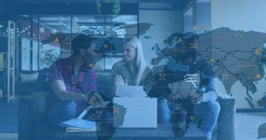 Meslektaşlar doktorlarını paylaşıyor ve dünya haritası UI sürüş iş analizinde kaybolurken dizüstü bilgisayara işaret ediyorlar. İşbirliği, takım çalışması, veri görselleştirme, modern ofis, iş stratejisi, dijital arayüz