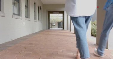 Yürüme yoluna giren kadınlar kemer yoluyla yürüyen sınıf arkadaşlarına katılıyorlar. Animasyon oklarıyla yol işaretleri bırakıyorlar. Günlük kıyafet, arkadaşlık, kampüs, gençlik, eğitim, mimari, açık hava