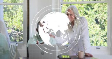 Adam dizüstü bilgisayarcı kadının masadaki tableti tıklaması dönen teknoloji küresi ve veri çizelgelerine neden oluyor. İşbirliği, dijital, yenilik, teknoloji, takım çalışması, çalışma alanı, veri görselleştirme