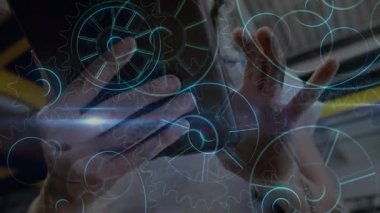 Kadın teknisyen, fabrika ışınları altında tablet tıkırdatıyor holografik dişlileri teftiş için yeniden hizalıyor. Teknoloji, yenilik, sanayi, mühendislik, fütüristik, otomasyon, imalat