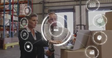 Müdür depo rafını işaret ediyor, lojistik analisti dizüstü bilgisayardaki envanteri onaylıyor. Sanayi, lojistik, teknoloji, tedarik zinciri, işbirliği, envanter, otomasyon