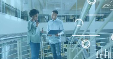 Akıllı telefonu dinleyen bir kadın ve bilgisayarını eğen bir adam fabrika asma katındaki zamanlayıcıları inceliyor. İşbirliği, veri görselleştirme, teknoloji, kentsel, profesyonel, yenilik, takım çalışması