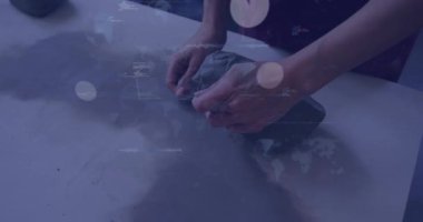 Sanatçı kil yoğurur sonra da dijital tablolar kaplarken heykel yapmak için üniforma şeritleri keser. El sanatları, imalat, dijital arayüz, kesinlik, yaratıcılık, işçilik, teknik