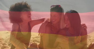 Eğilip kıvılcımlar saçan bir kadın arkadaşlarıyla plaj gölgesinde gülüyor. Arkadaşlık, açık hava, rahat, canlı, rahat, bağlanma, boş zaman