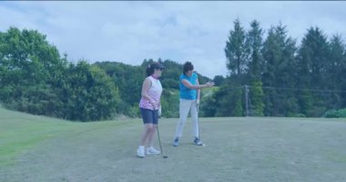 Eğitmen, golf antrenmanında isabetli atış yapabilmek için golf kulübüne gidiyor. Koçluk, akıl hocalığı, atletizm, açık hava, boş zaman, hareket, beceri geliştirme