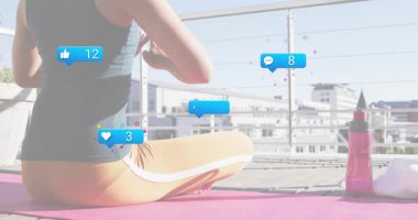 Erkek, çatıdaki pembe paspasda meditasyon yapıyor. Sosyal ikonlar alıyor ve sakin bir şekilde odaklanıyor. Meditasyon, farkındalık, şehir, rahatlama, sağIık, sükunet, tefekkür