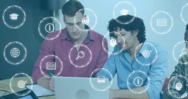 İki meslektaş dizüstü bilgisayarları takip ediyor ve dijital simgelerle kurumsal öğrenme için notlar alıyor. İşbirliği, takım çalışması, yenilik, teknoloji, ticaret, eğitim, strateji