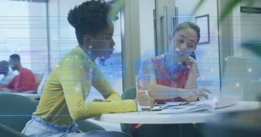 İş belgelerini inceleyen iki kadın holografik kılavuz sistemiyle yazı yazıyorlar. İşbirliği, takım çalışması, yenilik, teknoloji, dijital, profesyonel, çalışma alanı