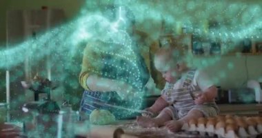 Anne hamur topluyor ve yemek dersinde dönen deniz mavisi parçacıklarıyla yol gösteriyor. Aile, kaynaşma, aile içi, kutlama, sıcaklık, sanatçılık, işçilik