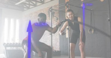 Savaş halatlarını çekiştiren, antrenörle çömelen, ölçüm ölçümleri yapan müşteriler performans ölçer. Güç, zindelik, dijital, eğitim, atletik, performans, egzersiz