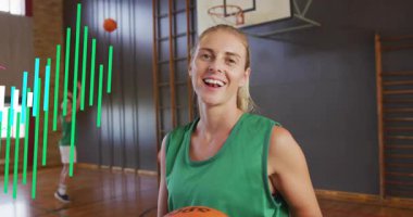 Spor salonunda elinde basketbol topu tutan bir kadın, nabzı atan, performansı takım arkadaşı atışı olarak gören bir kadın. Atletizm, takım çalışması, fitness, dijital, spor kıyafeti, enerjik, dinamik