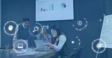 Dizüstü bilgisayar yazan bir kadın, satış simgeleri hazırlayan, strateji tartışan iş arkadaşlarının etrafında çizelgeler hazırlayan bir kadın. İşbirliği, takım çalışması, veri analizi, strateji, dijital görselleştirme, profesyonel, yenilik