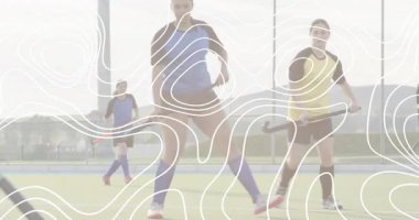 Çim hokeyi saldırganı defans oyuncusundan sıyrılıyor, düşük atış yapıyor ve kalede kıvılcımlar saçıyor. Sporcular, müsabaka, spor, aksiyon, takım çalışması, açık hava, dinamik