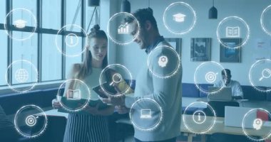 Stajyer ve meslektaşı tablet görüntülerini inceliyor, çalışma odasındaki araştırma simgelerini canlandırıyor. İşbirliği, takım çalışması, teknoloji, yenilik, modern, profesyonel, ağ oluşturma