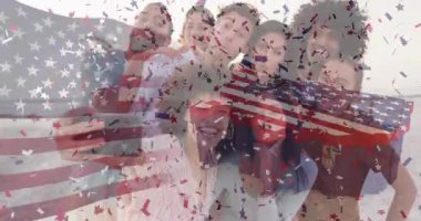 Sosyal medya için sahilde toplanan arkadaşlar selfie çekiyor ve konfeti ile bayrak şeritlerini aktifleştiriyorlar. Kutlama, yoldaşlık, vatanseverlik, boş zaman, mutluluk, canlı, açık hava