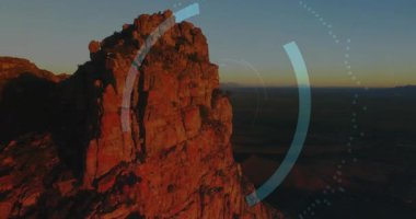 İHA gün batımında kırmızı uçurumun üzerinde süzülüyor güvenlik duvarı simgesiyle HUD 'u döndürmeye başlıyor. Peyzaj, drone, futuristik, teknoloji, güvenlik, dijital, dayanıklı