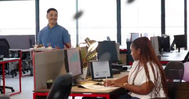 Erkek iş arkadaşı doğum günü pastasını tutarak içeri giriyor, iş arkadaşı için pasta yerleştiriyor, ofis sürprizi yaratıyor. İşbirliği, kutlama, profesyonel, çeşitlilik, işyeri, yenilik, motivasyon