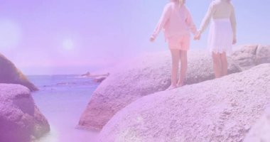 Güneş ışığı mercek parlamaları, okyanusa bakan kayalara bakan kız kardeşlere rehberlik eder, seyahat için kollarını kaldırır. Macera, keşif, arkadaşlık, açık hava, manzara, gençlik, doğal