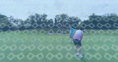 Kadın sopa sallıyor yeşil, yörünge çizgisi çizerek topu erkeğin yanındaki deliğe sokuyor. Açık hava, boş zaman, spor, eğlence, rekabet, rahatlama, zarafet.