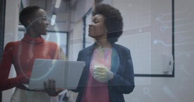 Teknik dizüstü bilgisayar kullanıcısı, kahve tutan meslektaşı veri tartışırken anahtar aktifleştirme grafiğini çalıştırıyor. İşbirliği, profesyonel, dijital, modern, iletişim, başlangıç, işyeri