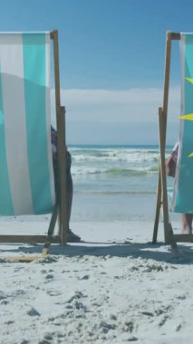 Güneşli sahilde güneşli yataklarda uzanan yaşlı Afro-Amerikan çiftin üzerine güneş animasyonu. Sağlıklı ve aktif emeklilik plaj tatili konsepti dijital olarak oluşturuldu.