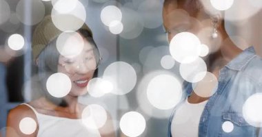 İş ikilisi akıllı telefonu dinliyor ve içeriği tarıyor. Ekranda el kol hareketi yapan kadın, iş arkadaşı kafa sallıyor. İşbirliği, dostluk, iletişim, teknoloji, çeşitlilik, modernlik, yenilik