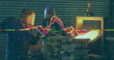 Kıdemli bir işçi el sallayan bir işçiyi işaret ederek dökümhane fırınına çubuk yerleştiriyor. Sanayi, zanaat, güvenlik, teknoloji, işbirliği, makine, kesinlik