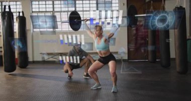 Spor salonunda ağırlık kaldıran bir sporcu veri grafikleri hareketliliğini takip ediyor. Kuvvet, eğitim, biyomekanik, hareket analizi, performans, dayanıklılık, fitness