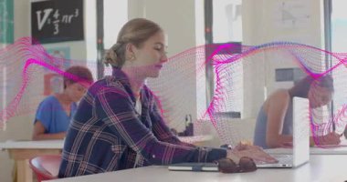 Çalışma alanında dizüstü bilgisayar açan, notlar yazarken masanın üzerinde dalgalanan pembe dalga formunu çağıran bir kadın. İşbirliği, eğitim, yenilik, odaklanma, konsantrasyon, teknoloji, öğrenme