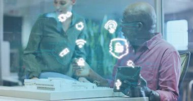 Senior man tapping tablet projecting lock icon on model and woman pointing security integration. Innovation, technology, collaboration, architecture, digital, futuristic, teamwork