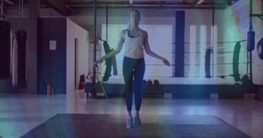 Kalçalarına ip sallayan, boks salonundaki kardiyoya atlayan, kollarını kavuşturan bir kadın. Fitness, cardio, athletic, training, sport, health, determination