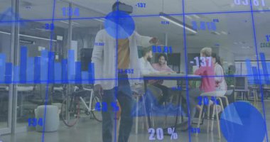 VR kullanıcısı kulaklığı ayarlarken aynı zamanda iş için holografik çizelgeler hazırlıyor ve takım öne eğiliyor. Teknoloji, işbirliği, veri, yenilik, fütürizm, işyeri, takım çalışması