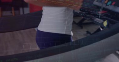 Orta yaşlı bir kadın koşu bandına güç veriyor ve koşuyor. Canlı spor performansı grafiklerini izliyor. Egzersiz, fitness, biyometrik, veri, performans, güç, sağlık