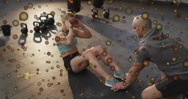 Kadın Kettlebell kum torbasıyla fitness oynarken antrenör müşterinin ayaklarını sağlama alıyor. Güç, fitness, antrenman, egzersiz, egzersiz, hareket, spor giyim