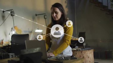 Atölyede dizüstü bilgisayar yazan ve dijital ağı gösteren ağ düğümleri üreten bir kadın. Yapı, atölye, yaratıcılık, bağlantı, yenilik, işçilik, sanayi